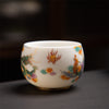 White ceramic tea cup with painted dragon and phoenix design