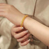 Gold-Tone Filigree Bangle with Green Stones