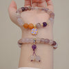 Two styles of violet golden silk jade bracelets worn on a wrist