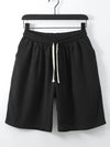Black men's casual shorts hanging on a hanger
