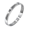 Silver-tone open cuff bracelet with engraved lotus flowers and Chinese script