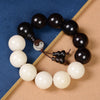 Black and white bodhi seed bracelet with yin yang charm on wooden background