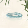 Close up of a light blue natural jade ring carved in a bamboo segment shape