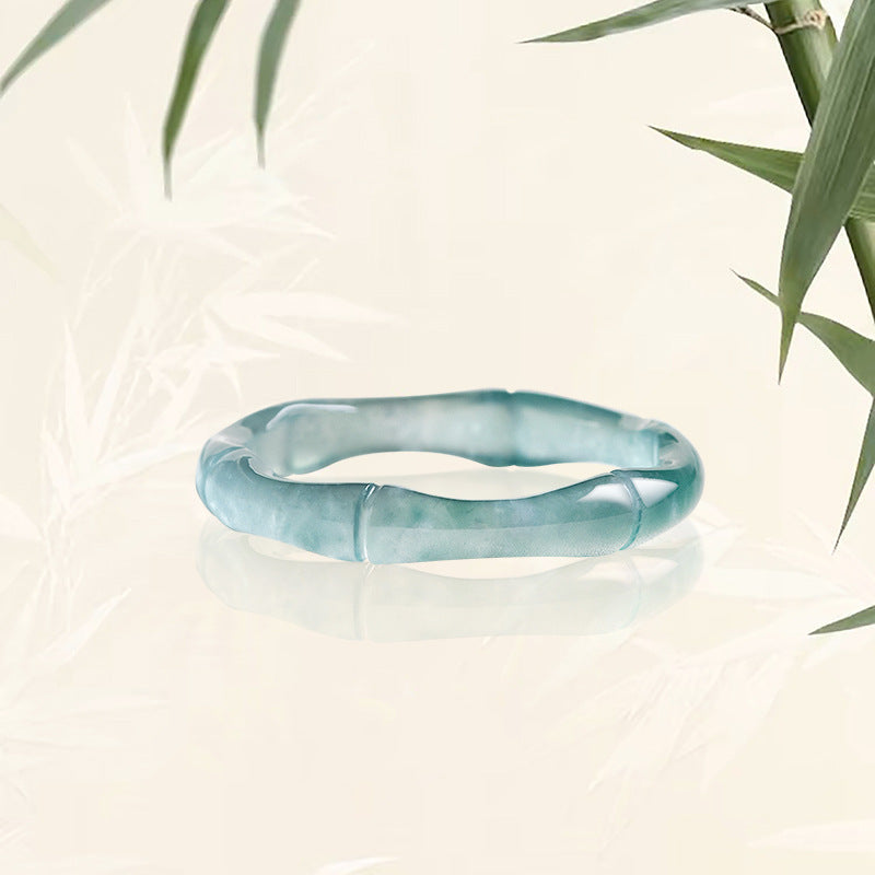 Close up of a light blue natural jade ring carved in a bamboo segment shape