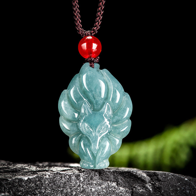 Carved blue water jade nine tailed fox pendant on a brown cord
