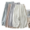 Light grey wide leg cotton linen pants with pleated waist detail laid flat