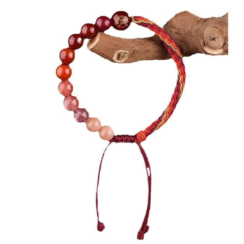 Woven red cord bracelet with gradient crystal beads worn on a wrist
