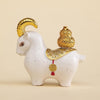 Red and white resin goat figurines with gold charms on a desk