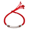 Close up of a red woven bracelet with a curved silver bar on a wrist