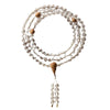 Coiled 108-bead white crystal mala with wood guru bead on a light background
