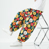 Man sitting in a chair wearing colorful floral print harem pants