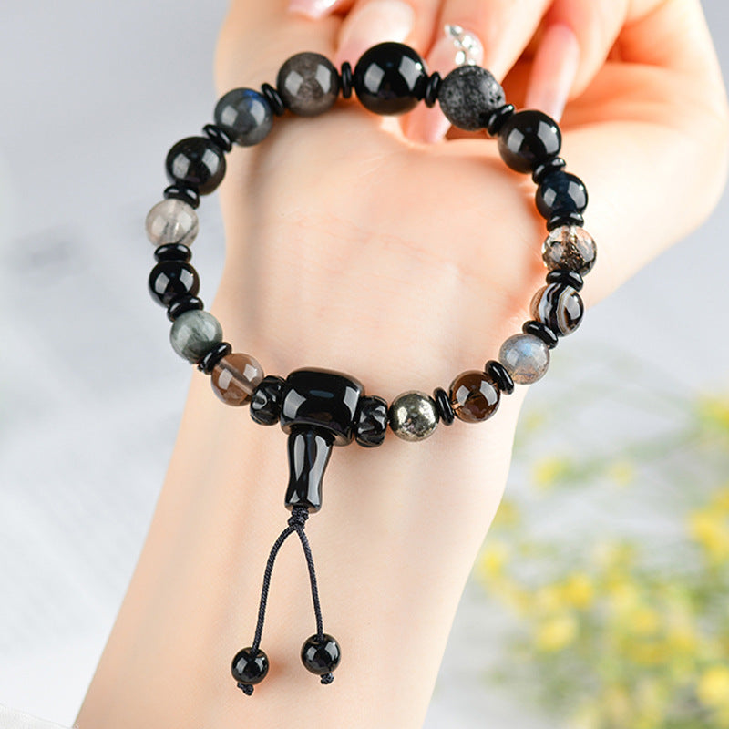 Hand holding a dark mixed crystal beaded bracelet with a knot closure