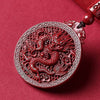 Red carved cinnabar pendant necklace featuring a detailed dragon design on a black cord