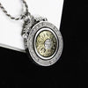 Close up of a silver tone copper pendant with a gold tone center that rotates
