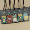 Rectangular ebony wood pendant necklace with colorful stone inlay and gold-tone deity figure