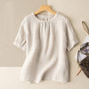 Beige women's casual half sleeve shirt with round neck hanging on a wooden hanger