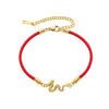 Gold plated copper dragon charm on a braided red rope bracelet
