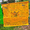 Yellow Tibetan prayer flag with Windhorse and mantras hanging outdoors