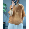 Woman wearing a loose orange embroidered top with frog buttons