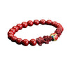 Red cinnabar beaded bracelet with two carved pixiu figures and a colorful center bead