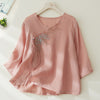 Pink embroidered cotton linen top with tassel detail on a hanger
