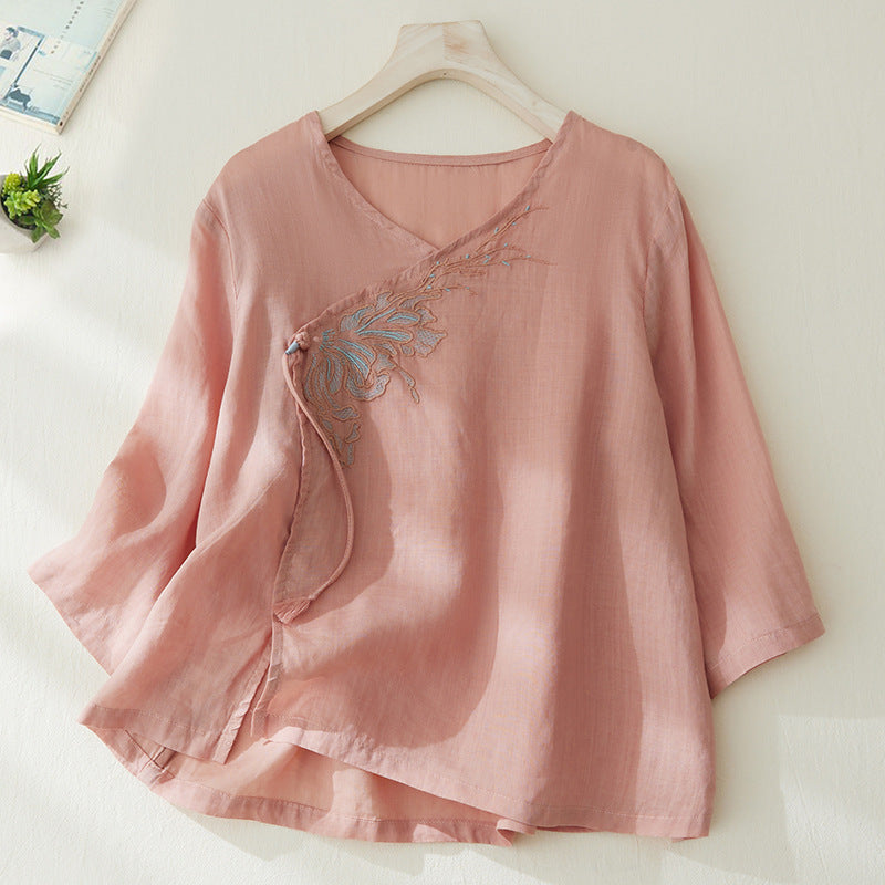 Pink embroidered cotton linen top with tassel detail on a hanger