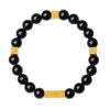 Close up of black obsidian bead bracelet with gold square charms on a wrist