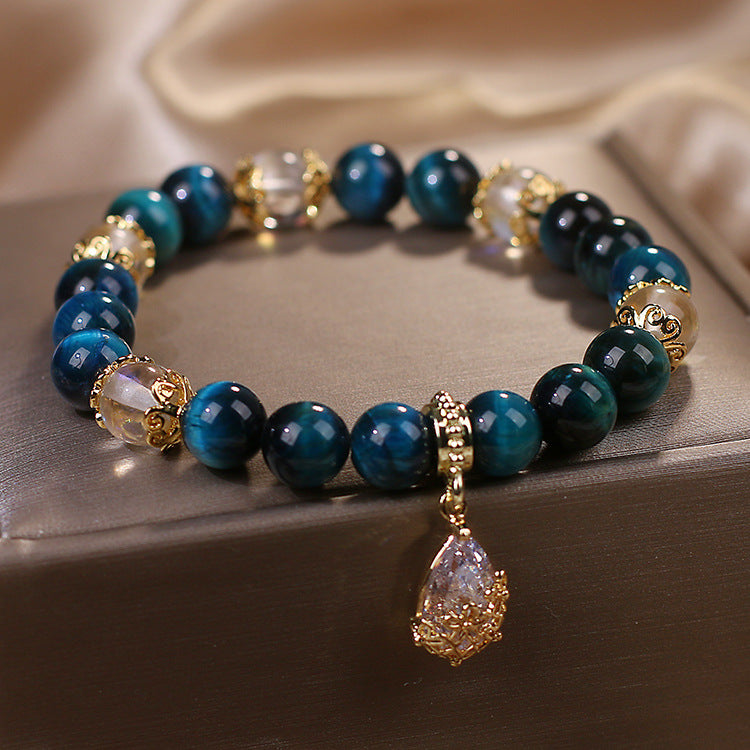 Blue tiger eye bead bracelet with gold accents and a crystal drop pendant