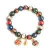 Colorful Liuli glass bead bracelet with gold-tone animal charms on a grey background