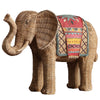 Two resin elephant statues with a woven texture and colorful blankets on a wooden table.