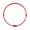 Close up of a red braided cord bracelet with three small brown abacus beads