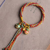 Close up of a colorful braided cord bracelet with small animal charms
