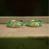 Close up of a green chalcedony ring with gold filigree details on a wooden surface