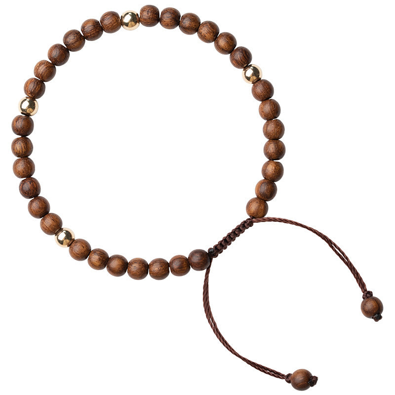 Close-up of a brown wooden bead bracelet with gold accents on a wrist