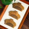 Three green sandalwood combs shaped like cheongsam collars with floral carvings arranged on a white background.