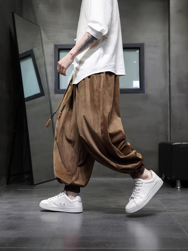 Man wearing brown loose harem pants with a white shirt and sneakers