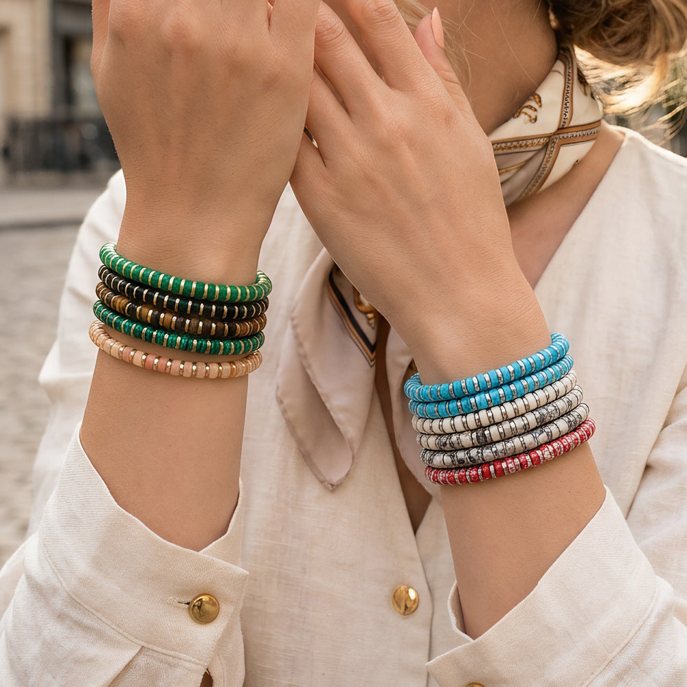 Stack of colorful geometric stone bracelets on a woman's wrist