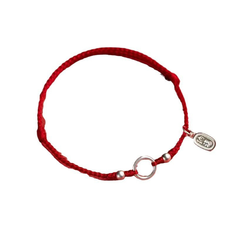 Braided red string bracelet with silver tone peace buckle and charm