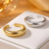 Gold and silver hammered copper open rings on a white display block