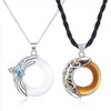 Two necklaces with crescent moon pendants holding white and brown rings, accented by a crown charm.