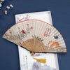 Open folding fan with cotton linen fabric showing a painted cat and flowers