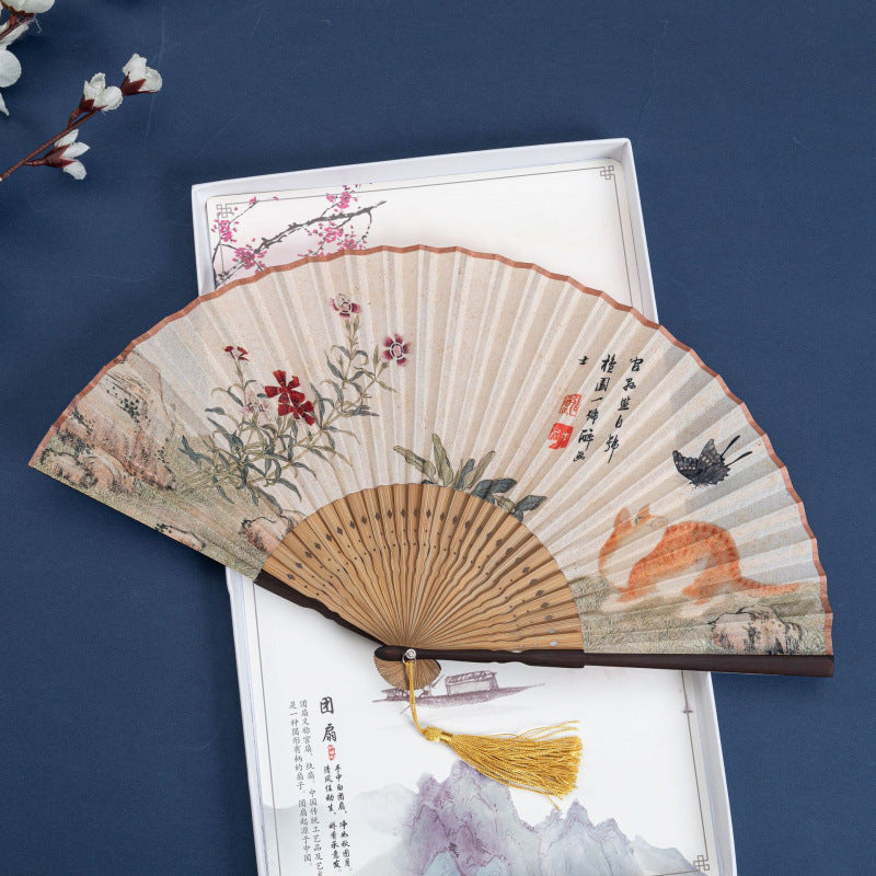 Open folding fan with cotton linen fabric showing a painted cat and flowers