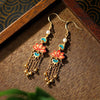 Gold tone copper earrings with red enamel lotus flowers and chain tassels
