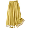 Yellow wide leg pants with white lace trim at the bottom hem