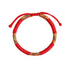 Close up of a red braided bracelet with multicolor King Kong knot details