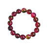 Close-up of a multi-colored pink and green crystal beaded bracelet on a ceramic surface