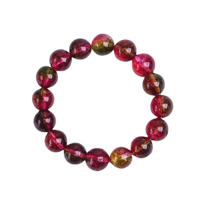 Close-up of a multi-colored pink and green crystal beaded bracelet on a ceramic surface