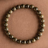 Close-up of a round wooden bead bracelet with natural grain on a textured brown background