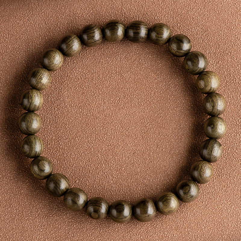 Close-up of a round wooden bead bracelet with natural grain on a textured brown background