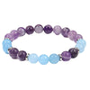 Close up of handmade bracelet with purple amethyst and light blue aquamarine beads on a white surface